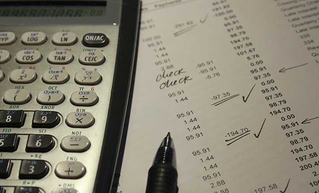 Auf einer Abrechnung liegen ein Taschenrechner und ein Kulli.